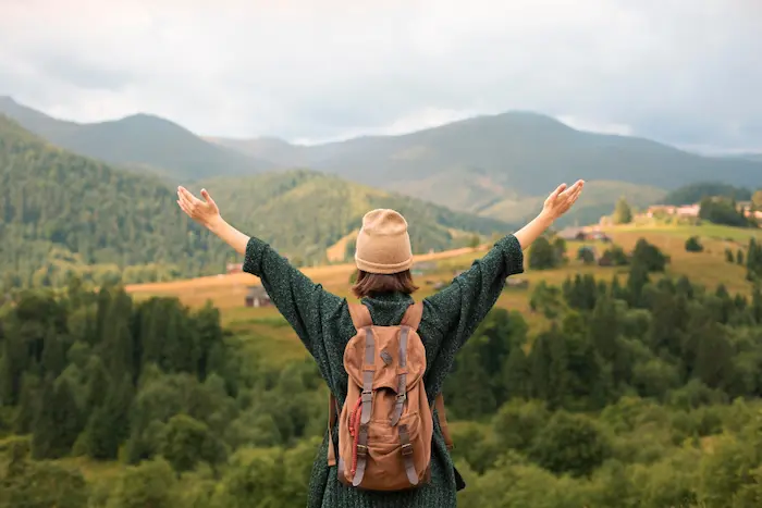 mujer feliz viajando sin gastar mucho dinero
