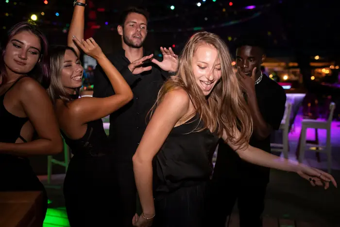 mujer con sus amigos bailando en una discoteca