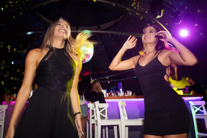 dos amigos disfrutando  de la música en una discoteca