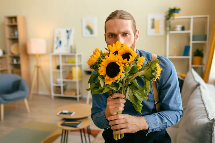 joven oliendo unos girasoles que se los entregará a una persona especial