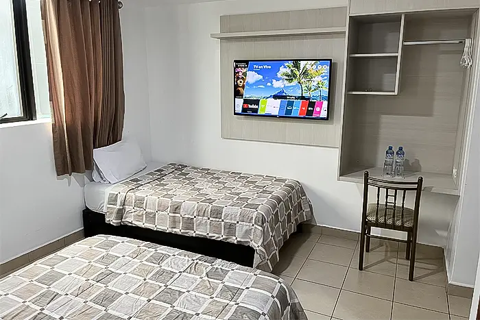 habitación doble con buen espacio, dos camas amplias y una linda tv