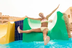 mujer jugando en un tobogan de piscina