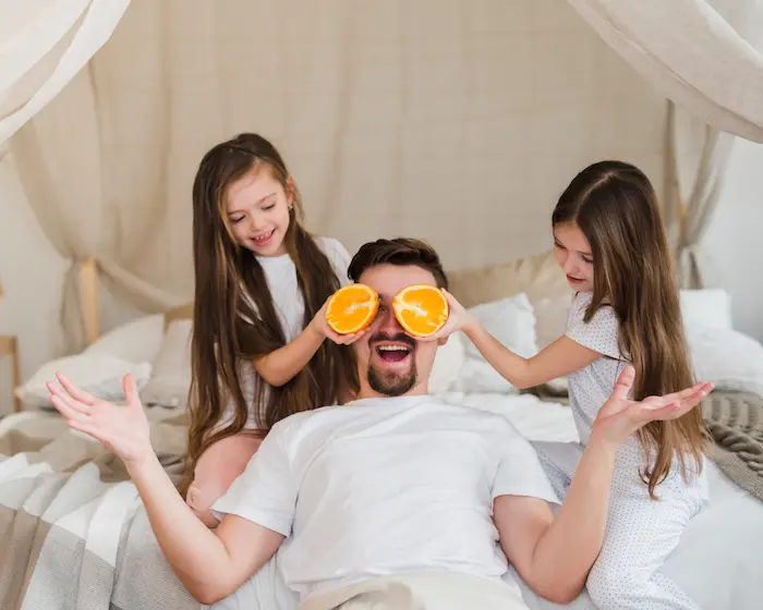 hombre feliz con sus hijas en una habitación doble